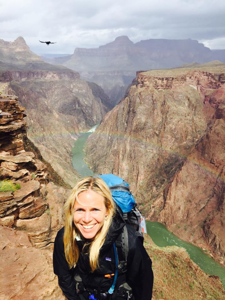 Sara Schulting Kranz in the grand canyon with a rainbow behind her